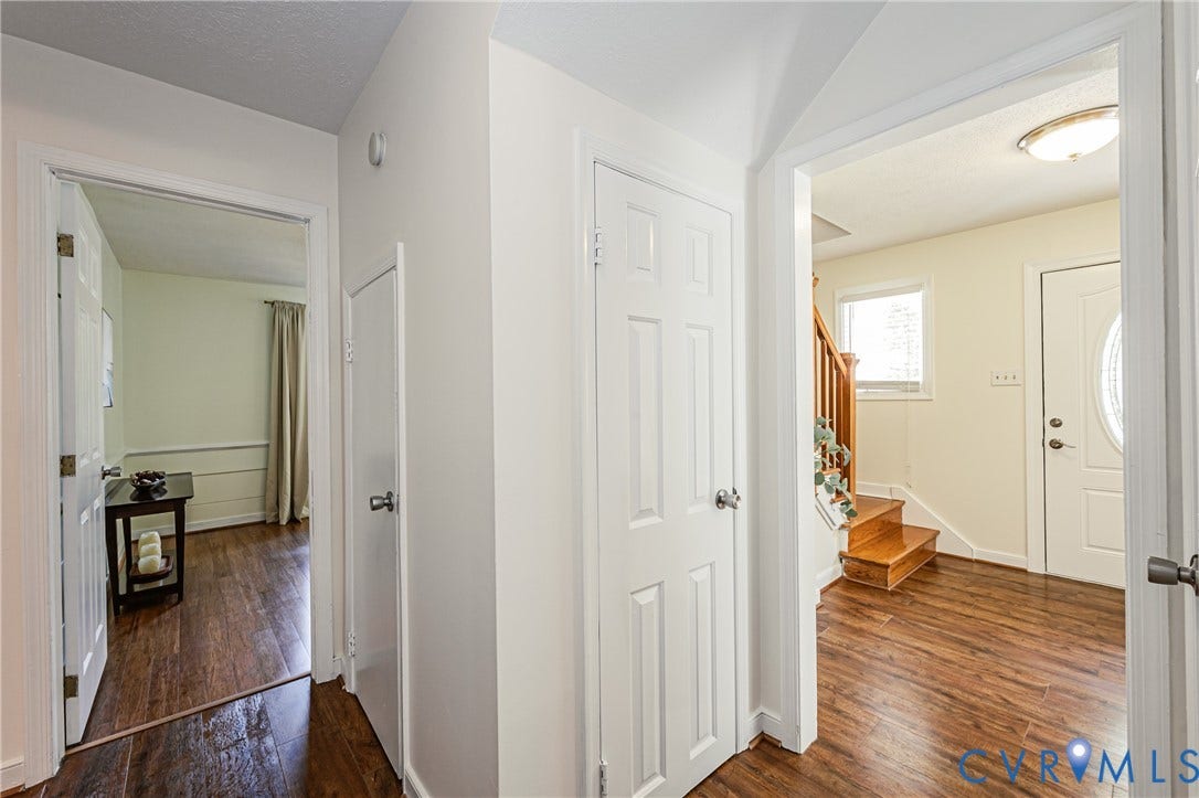 1608 Lochwood Drive, Henrico, VA 23238 Bright hallway with wood-finish flooring throughout, white six-panel interior doors, and abundant natural light from multiple windows