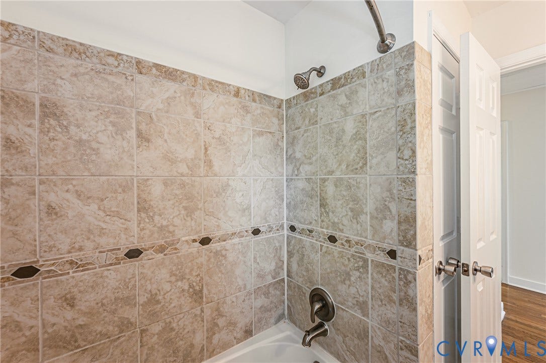 1608 Lochwood Drive, Henrico, VA 23238 Tiled tub surround featuring a decorative accent band and brushed nickel fixtures