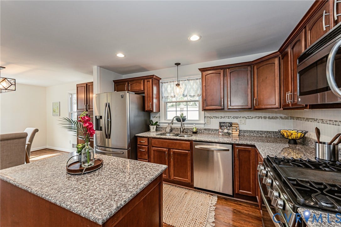 1608 Lochwood Drive, Henrico, VA 23238 Chef's kitchen featuring rich wood cabinetry, stainless steel appliances, granite countertops, and a decorative tile backsplash