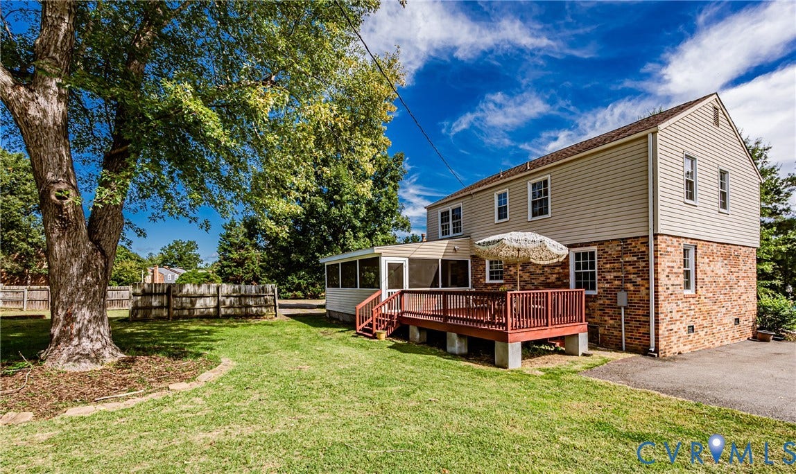 1608 Lochwood Drive, Henrico, VA 23238 Spacious backyard featuring a large mature tree, wood deck with railing, and a screened-in porch