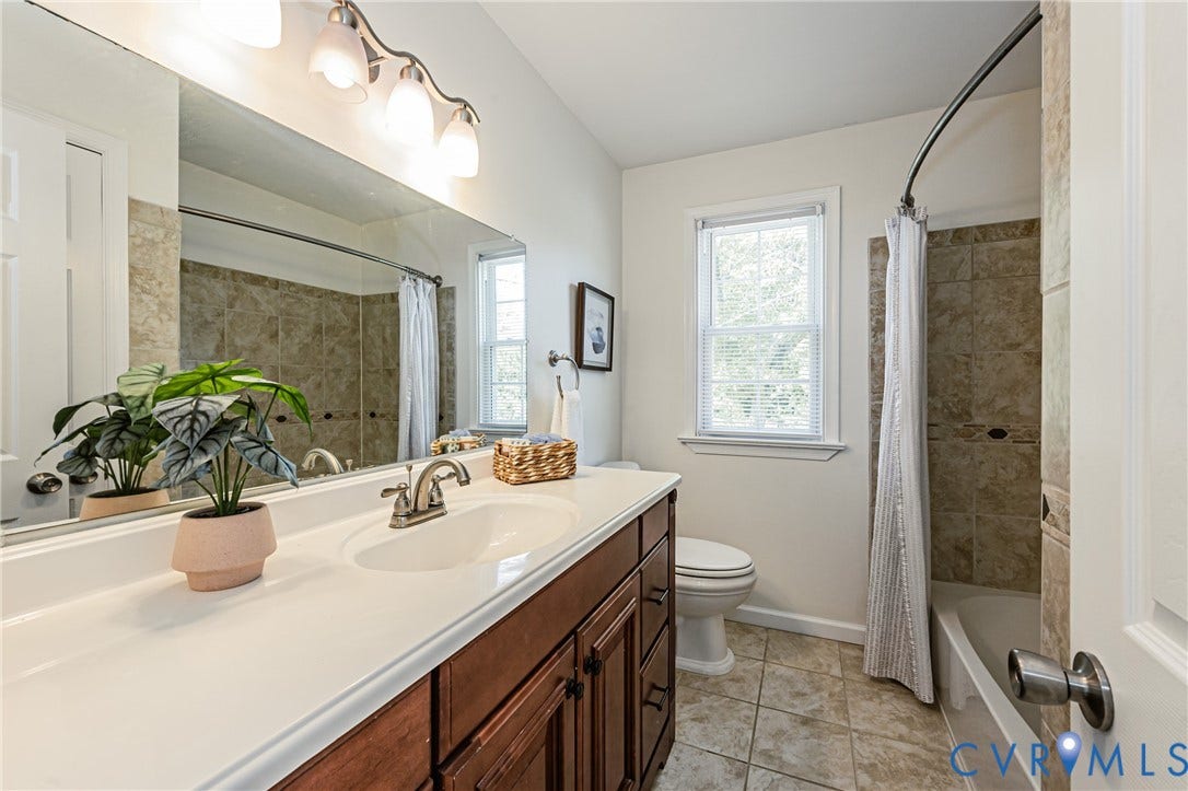 1608 Lochwood Drive, Henrico, VA 23238 Spa-inspired primary bathroom featuring a wood-finish vanity with dual sinks, quartz countertop, and brushed nickel faucetry