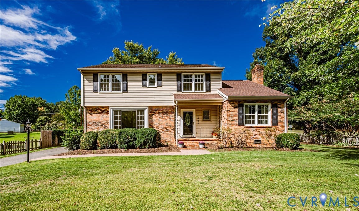 1608 Lochwood Drive, Henrico, VA 23238 Two-story residence featuring brick and siding facade, contrasting dark shutters, a covered front entry, and a prominent brick chimney