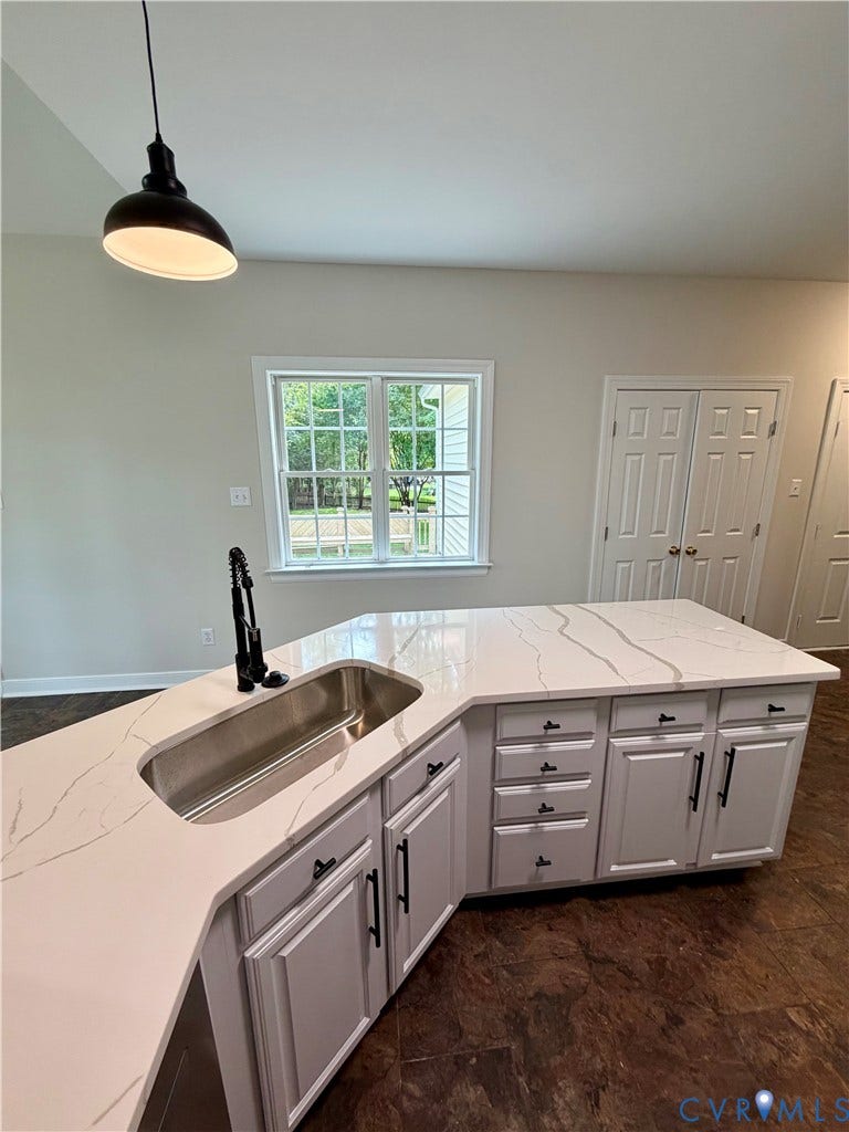 10721 Sheppards Way Drive, Sheppards Way, Glen Allen, VA 23060 Spacious kitchen island featuring a deep undermount sink with a matte black faucet, white countertops with subtle veining, ample built-in cabinetry, and wood-finish flooring