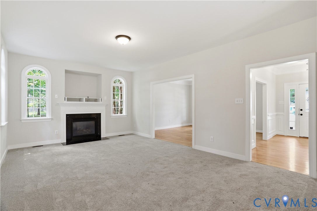 10721 Sheppards Way Drive, Sheppards Way, Glen Allen, VA 23060 Carpeted living area featuring a fireplace with a white mantel, arched windows, and recessed shelving
