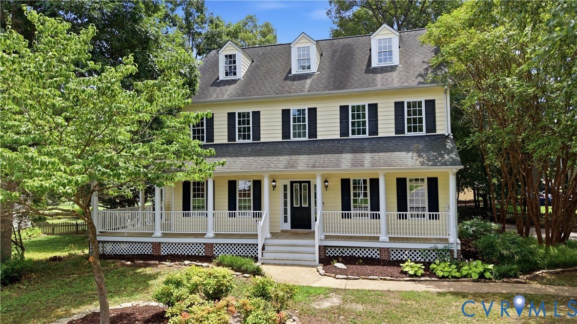 10721 Sheppards Way Drive, Sheppards Way, Glen Allen, VA 23060 Yellow siding exterior with black shutters, dormer windows, full-length front porch with white railings, columns, and lattice accents, and mature landscaping