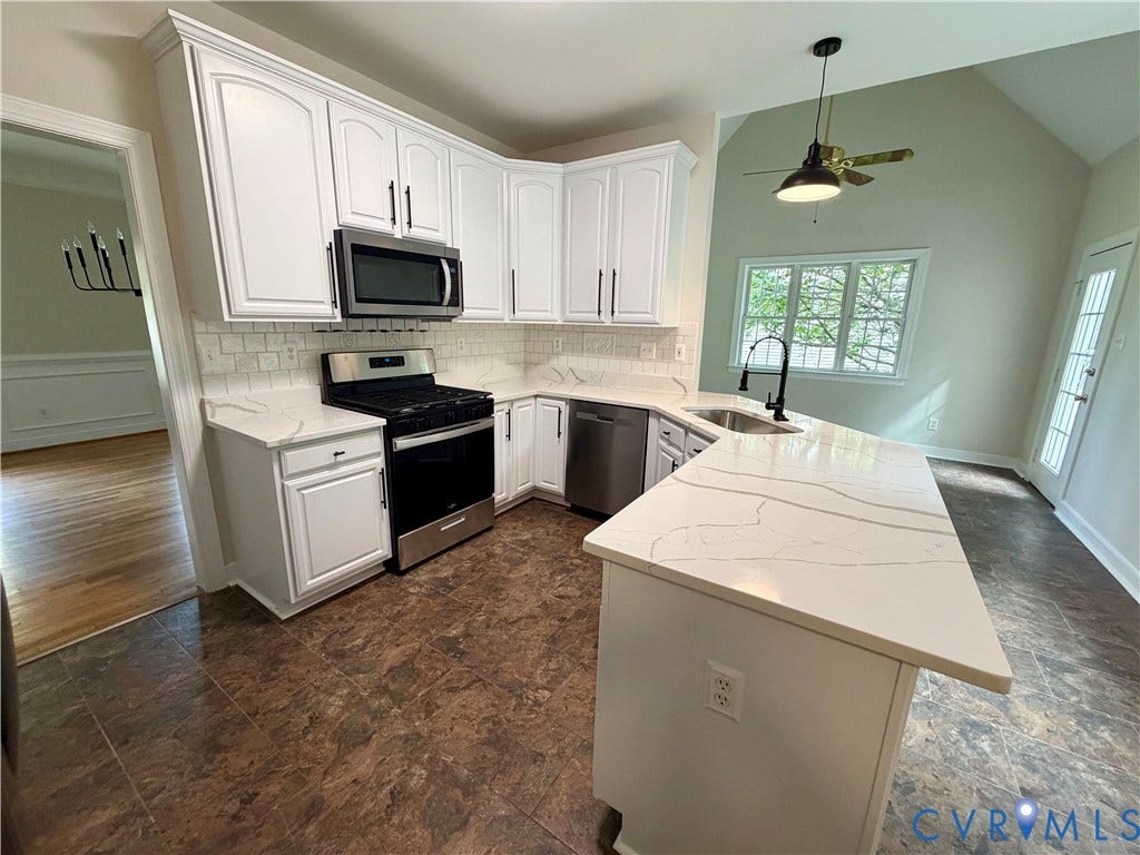 10721 Sheppards Way Drive, Sheppards Way, Glen Allen, VA 23060 White cabinetry, stainless steel appliances, white patterned countertops, tile backsplash, and vaulted ceilings