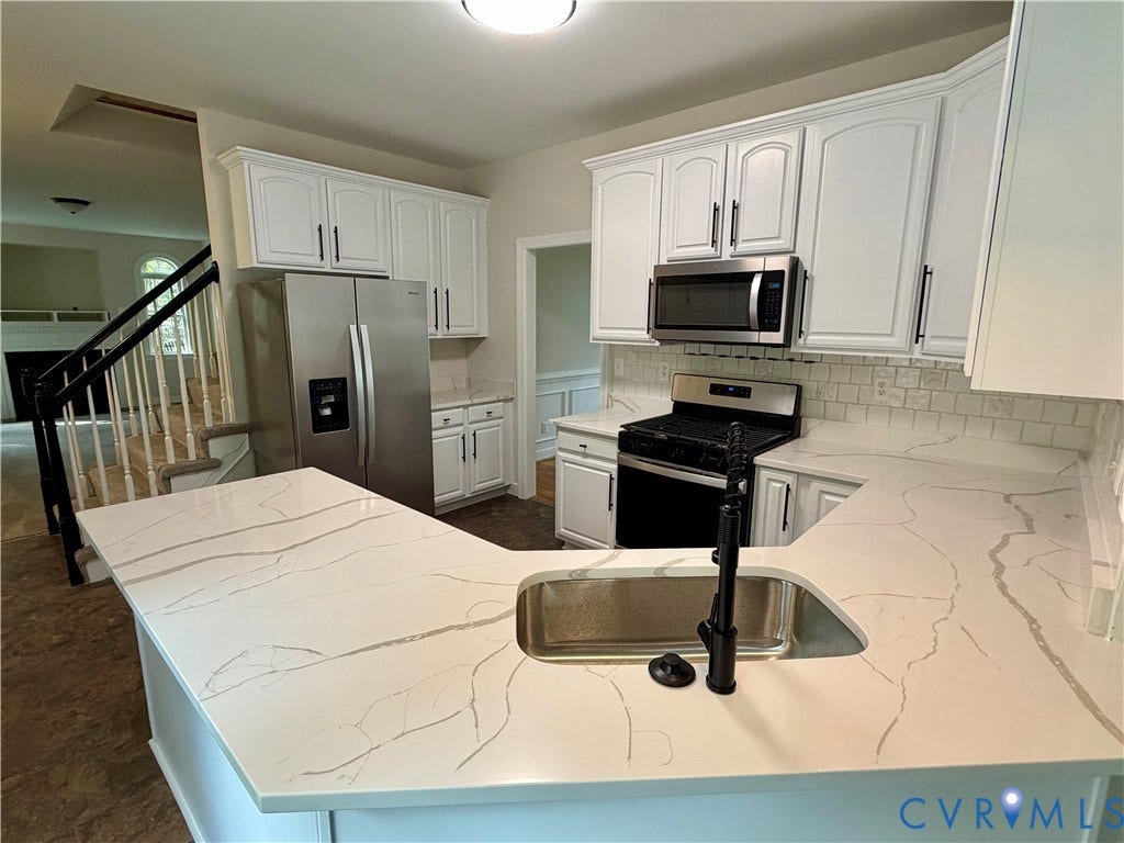 10721 Sheppards Way Drive, Sheppards Way, Glen Allen, VA 23060 White cabinetry with dark hardware, stainless steel appliances, light-toned countertops with veining, subway tile backsplash, and a built-in sink with a dark faucet