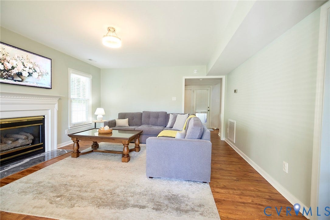 2633 Bradway Lane, Henrico, VA 23233 Spacious living room featuring hardwood flooring, a gas fireplace with white mantelpiece, recessed ceiling lighting, and abundant natural light from multiple windows
