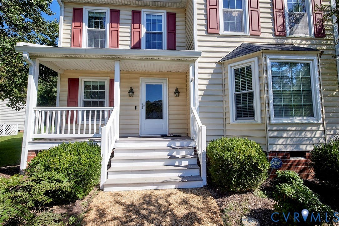 2633 Bradway Lane, Henrico, VA 23233 Charming Colonial-style home featuring a welcoming front entrance with a covered porch, white railings, and brick foundation