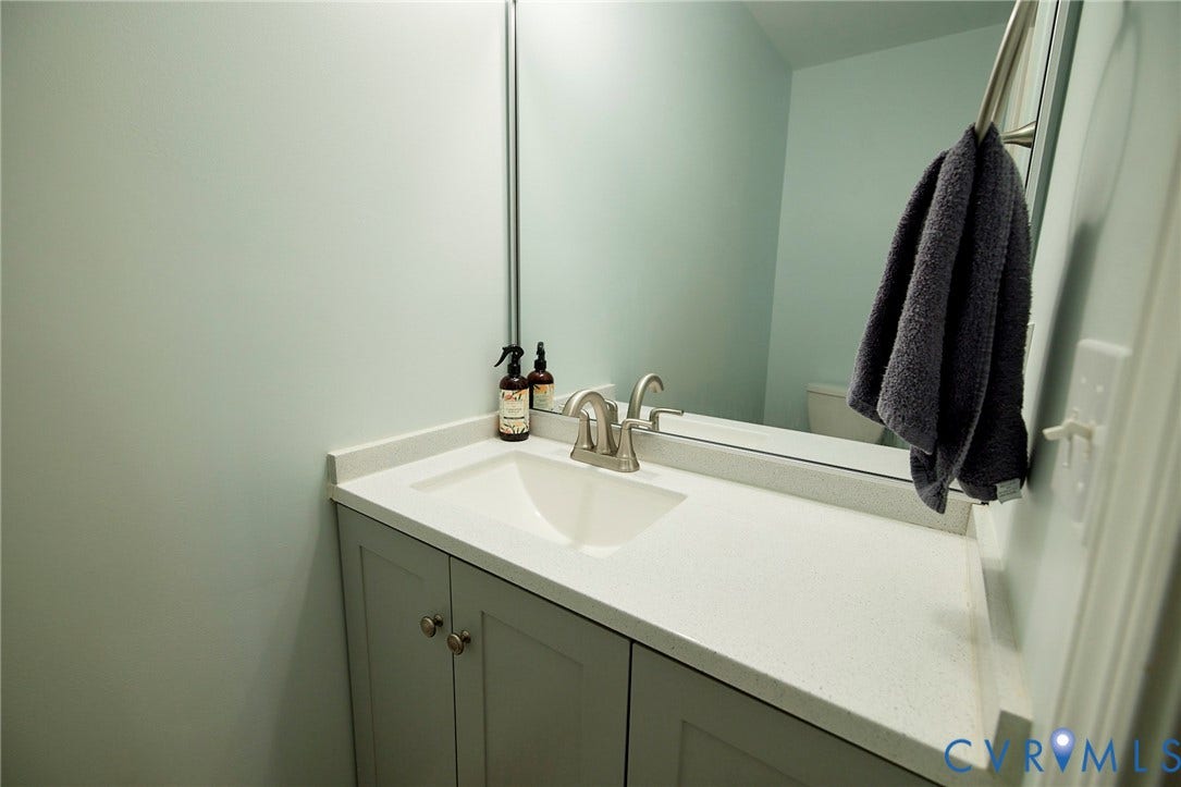 2633 Bradway Lane, Henrico, VA 23233 Elegant bathroom vanity featuring a white quartz countertop, undermount sink with brushed nickel faucet, and soft-close cabinetry with hardware accents