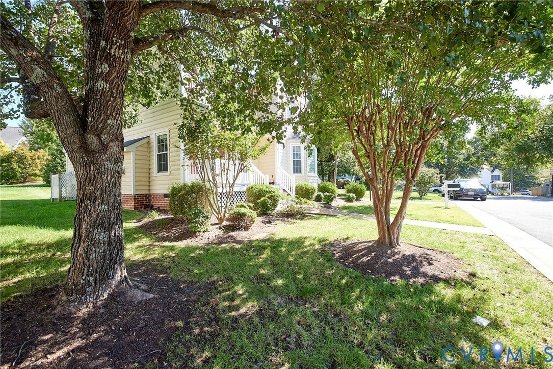 2633 Bradway Lane, Henrico, VA 23233 Lush front yard with mature trees, established landscaping, and a sidewalk