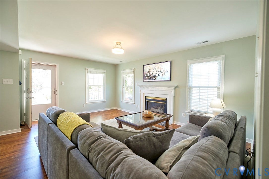 2633 Bradway Lane, Henrico, VA 23233 Bright and open living area featuring hardwood flooring, a gas fireplace with surround mantel, multiple windows with natural light, and recessed ceiling lighting