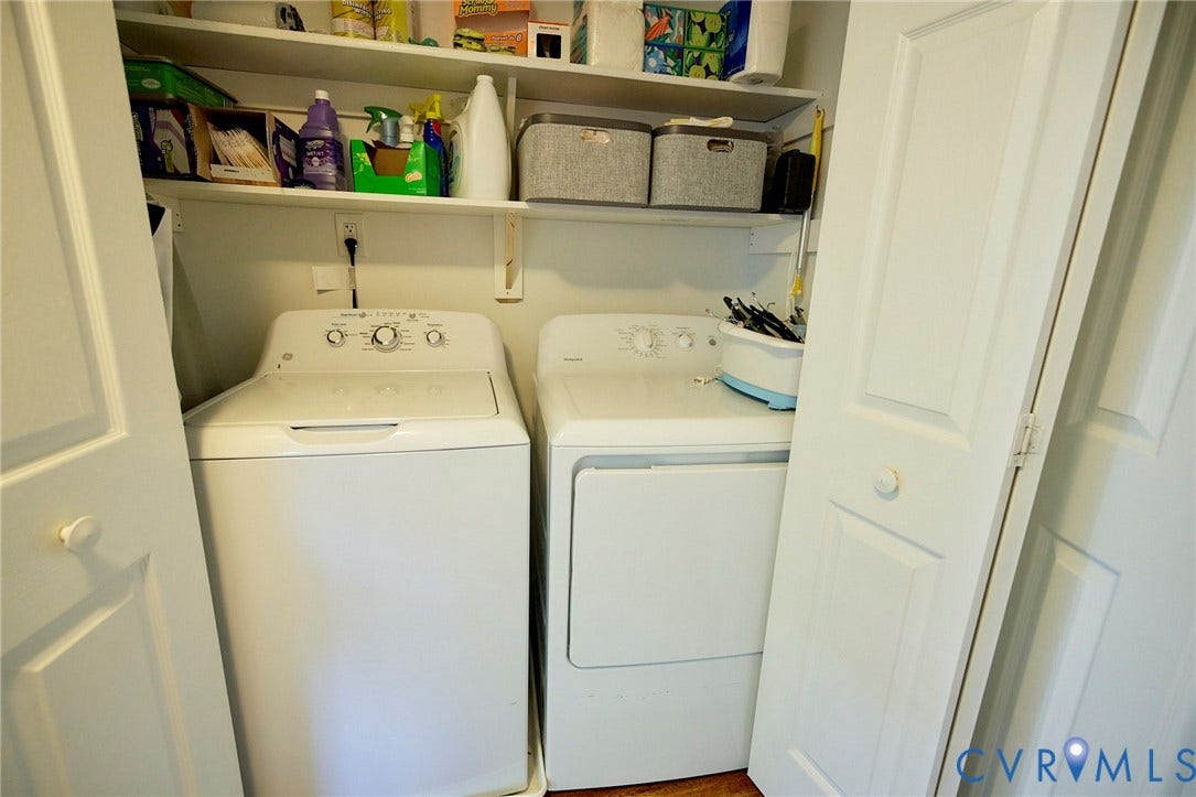 2633 Bradway Lane, Henrico, VA 23233 Dedicated laundry closet featuring a full-size top-load washer and electric dryer with convenient shelving for storage supplies and household essentials