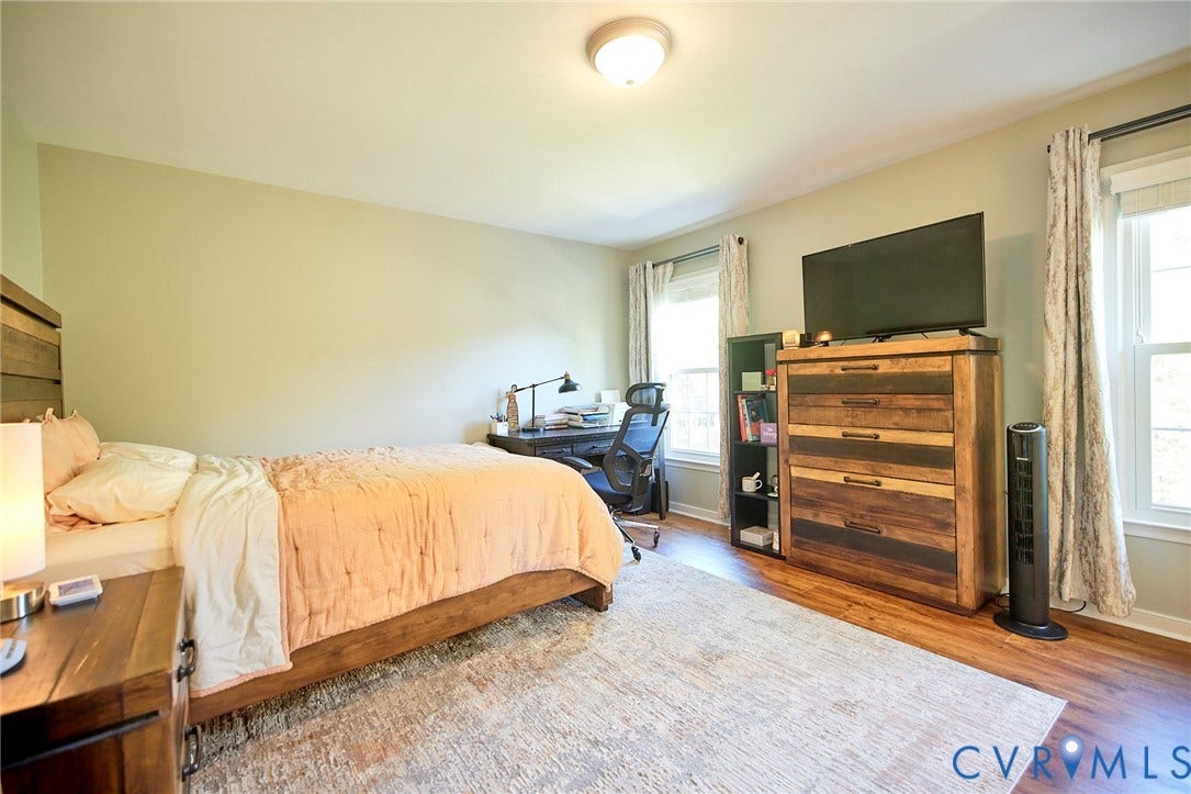 2633 Bradway Lane, Henrico, VA 23233 Spacious primary bedroom with hardwood flooring, soft neutral wall finishes, and abundant natural light from multiple windows