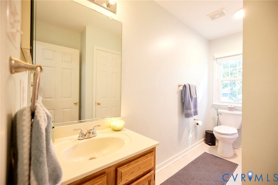 2633 Bradway Lane, Henrico, VA 23233 Bathroom featuring a single vanity, undermount sink, wall-mounted mirror, and a window