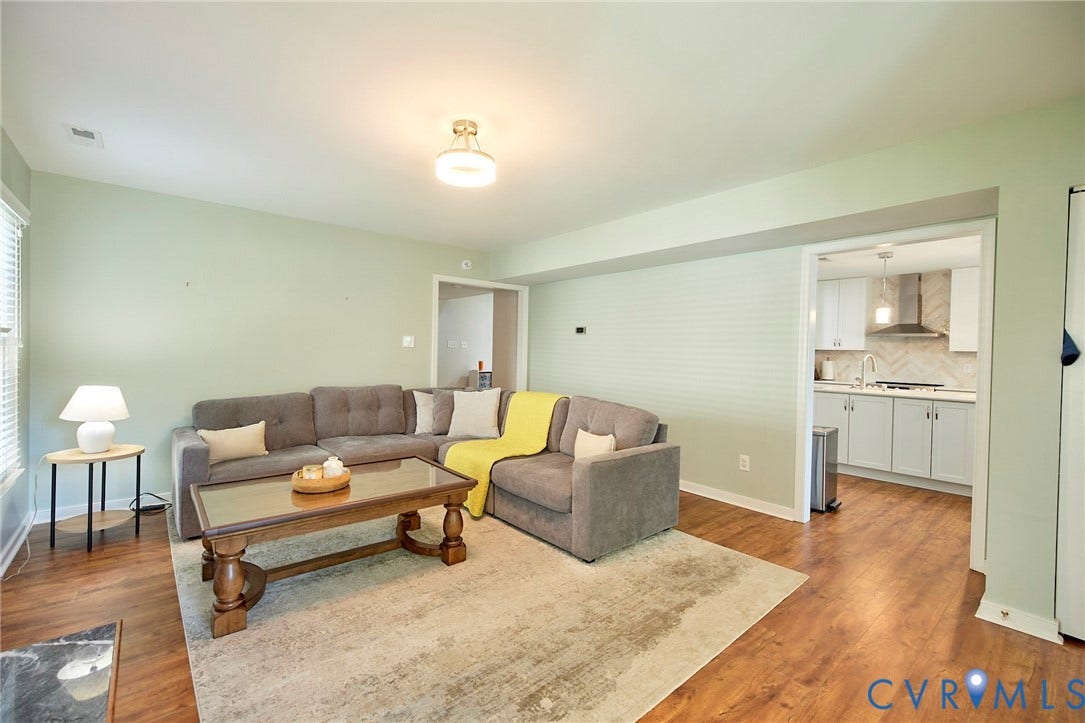 2633 Bradway Lane, Henrico, VA 23233 Open-concept living area showcasing hardwood flooring, neutral wall finishes, and abundant natural light from recessed ceiling fixtures