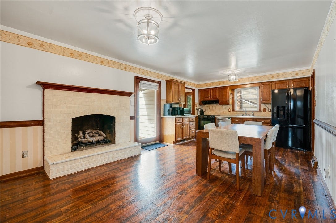 7516 Oakmont Drive, Henrico, VA 23228 Brick fireplace with wood mantel, kitchen with wood cabinetry, and appliances
