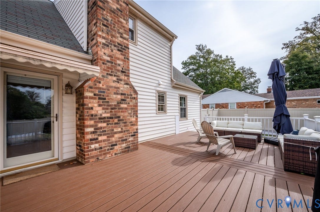 7516 Oakmont Drive, Henrico, VA 23228 Spacious deck with white railing, brick chimney, and siding exterior
