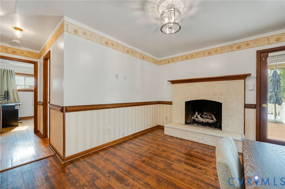 7516 Oakmont Drive, Henrico, VA 23228 Wood-finish flooring, brick fireplace, wood trim, and a glass-paneled exterior door