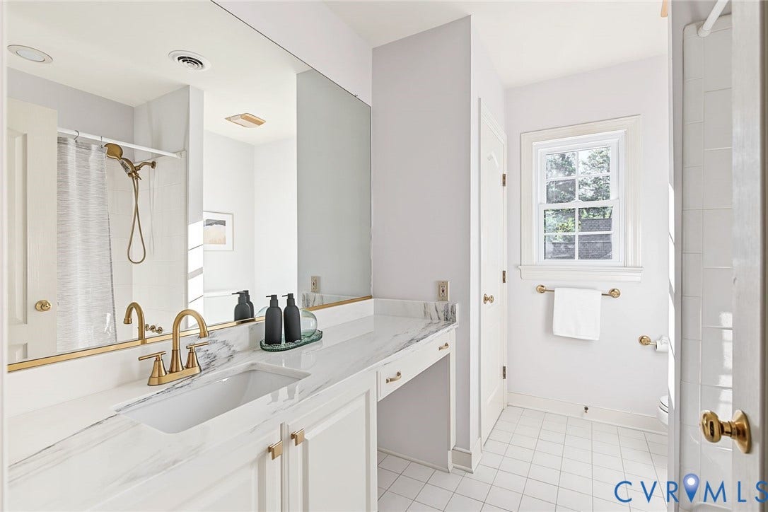 2825 Oak Point Lane, Barrington, Henrico, VA 23233 Bedroom 3's full bathroom with new quartz counters, updated brass fixtures and timeless tile flooring.