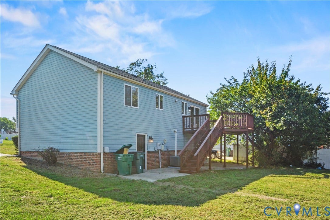 2836 Neale Street, 5-040, Henrico, VA 23223 Expansive backyard with a manicured lawn, multi-level wood deck, and mature trees
