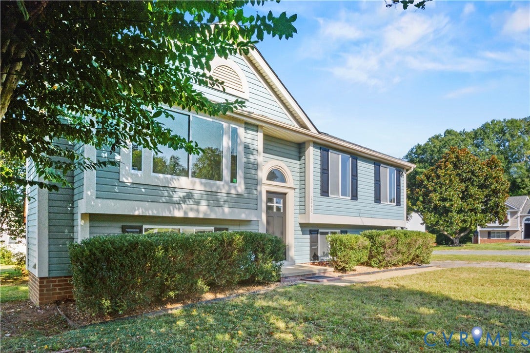 2836 Neale Street, 5-040, Henrico, VA 23223 Split-level residence featuring light blue siding, a prominent arched entry, and a mix of large picture windows and multiple-pane windows