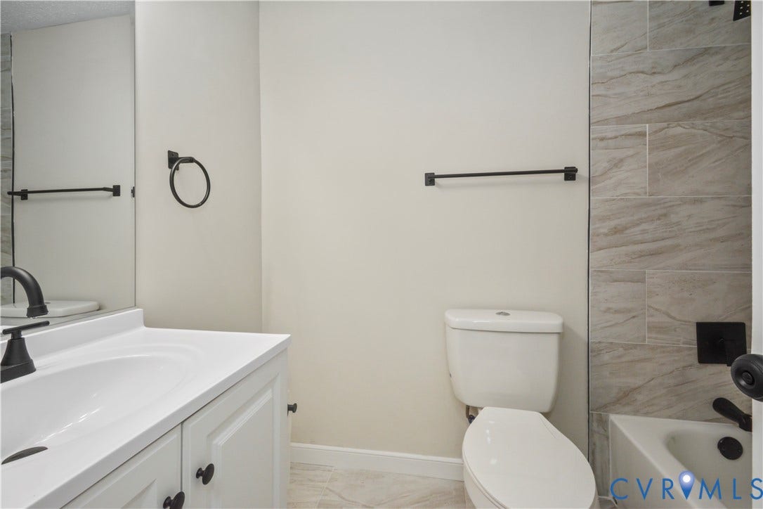 2836 Neale Street, 5-040, Henrico, VA 23223 White vanity with integrated sink, matte black faucet, and white paneled cabinetry