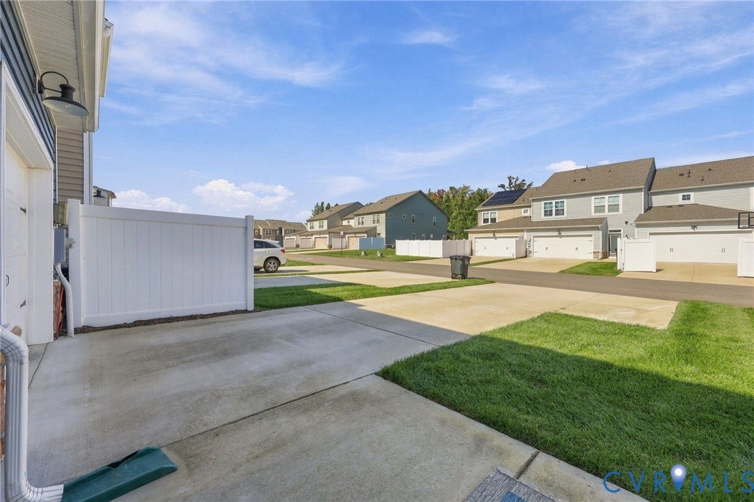 10818 Ashton Poole Place, Henrico, VA 23059 Concrete driveway and walkway with a white privacy fence