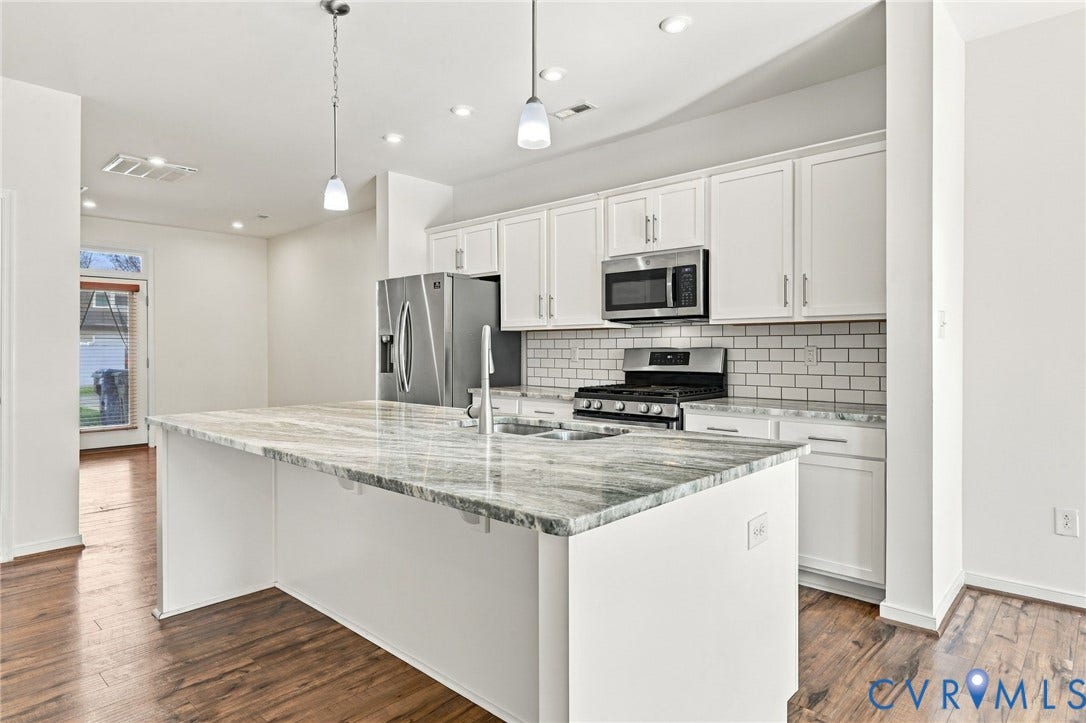 10818 Ashton Poole Place, Henrico, VA 23059 Kitchen featuring a large central island with a stone countertop, white shaker-style cabinetry, stainless steel appliances, and wood-finish flooring