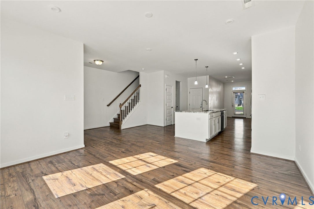10818 Ashton Poole Place, Henrico, VA 23059 Open-concept living area with wood-finish flooring, a kitchen island with stone countertop, stainless steel appliances, and recessed lighting