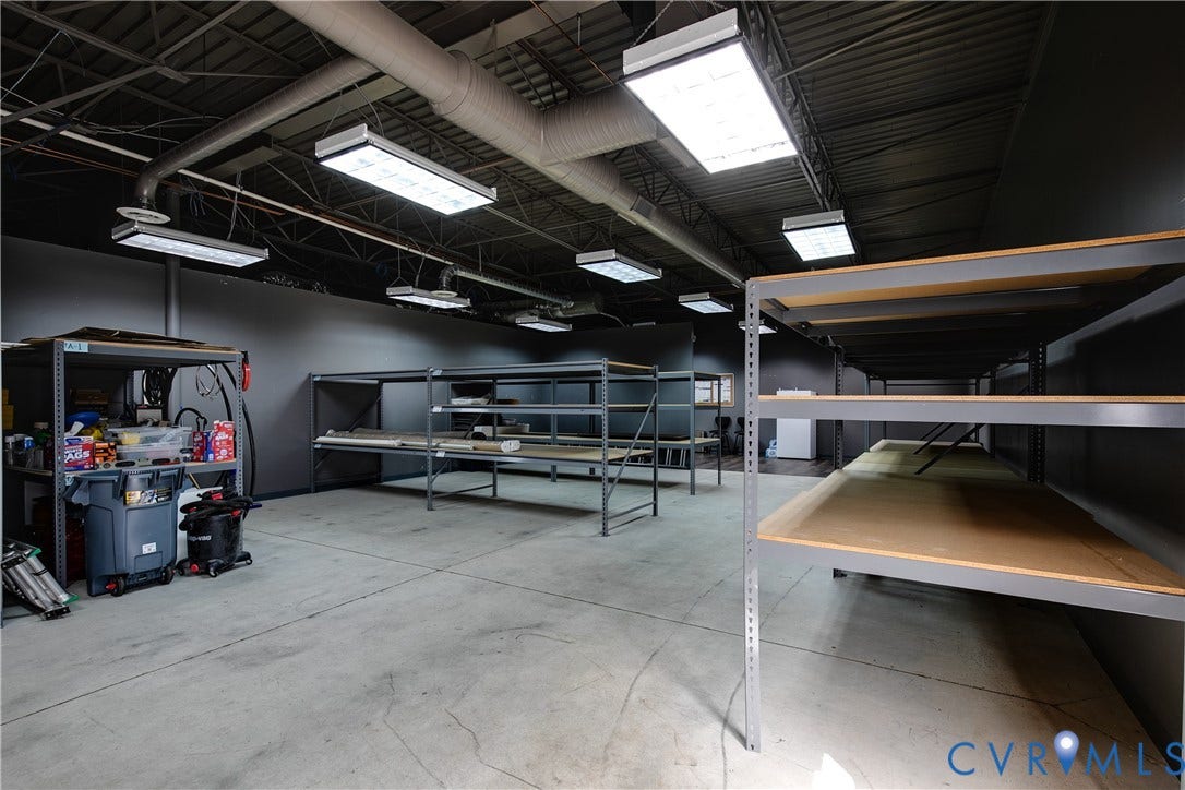 2575 Homeview Drive, Henrico, VA 23294 Concrete flooring with exposed ductwork and ceiling structure, multiple fluorescent light fixtures, and extensive modular shelving units