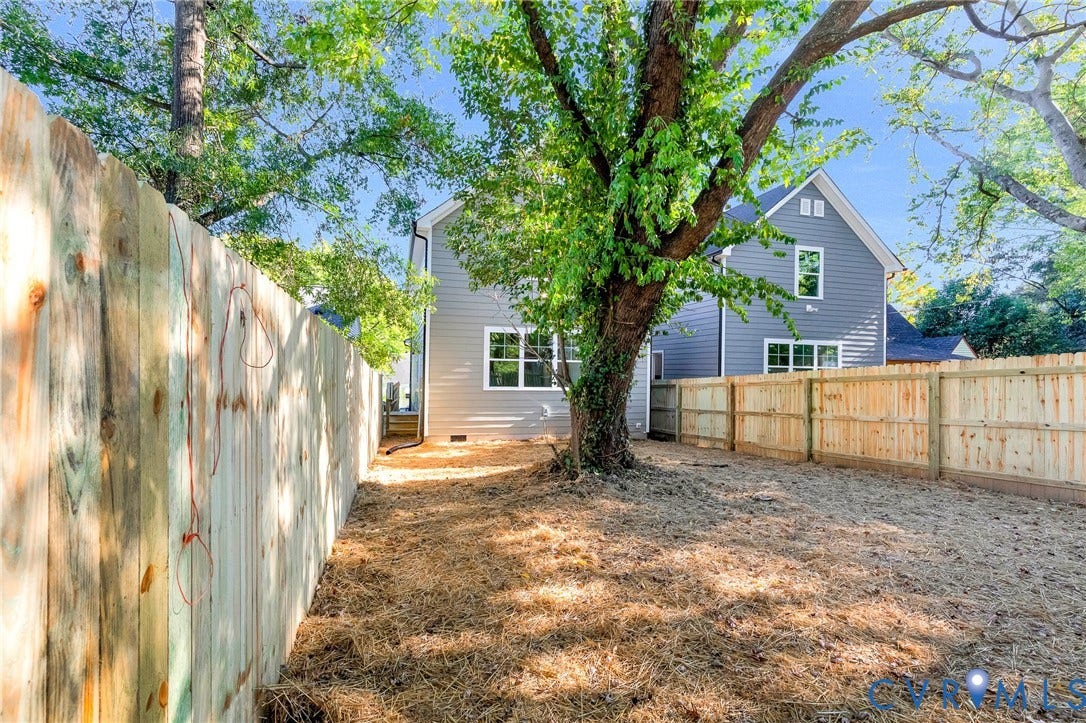 1807 Gordon Avenue, Oak Grove, Oak Grove, VA 23224 Expansive backyard featuring a new wood fence, mature tree, and a two-story residence with gray siding