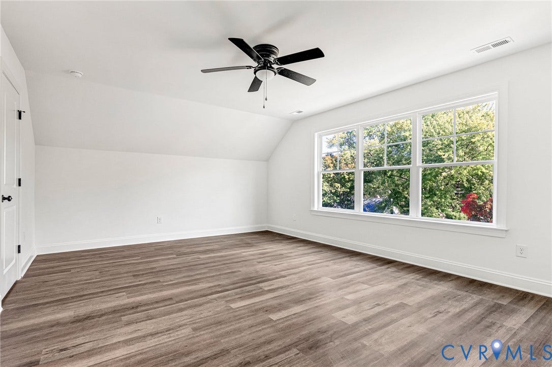 1807 Gordon Avenue, Oak Grove, Oak Grove, VA 23224 Spacious room featuring wood-finish flooring, a large multi-pane window, and a ceiling fan