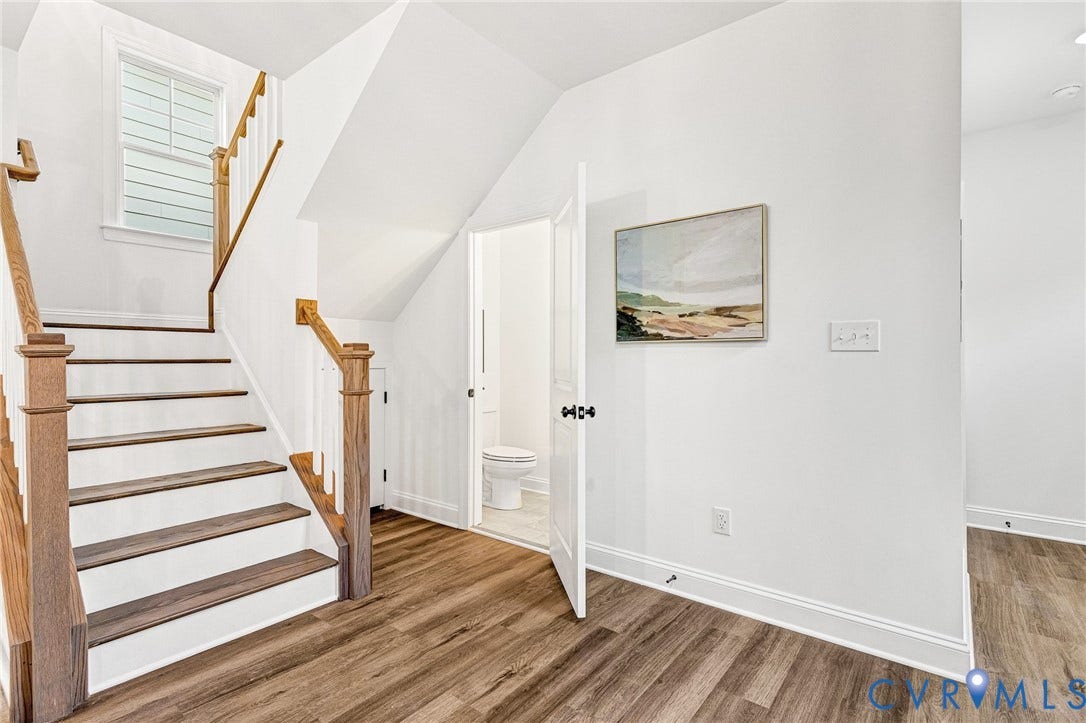 1807 Gordon Avenue, Oak Grove, Oak Grove, VA 23224 Wood-finish flooring throughout, white painted walls, and a staircase featuring wood handrails and risers