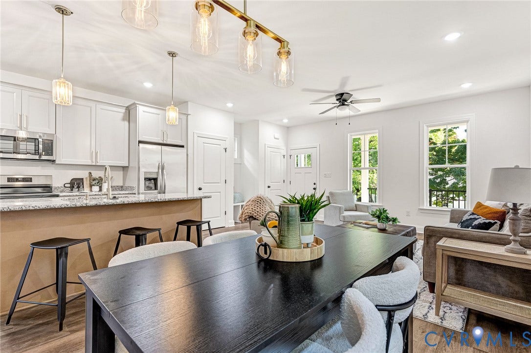 1807 Gordon Avenue, Oak Grove, Oak Grove, VA 23224 Open-concept living space with wood-finish flooring, white cabinetry, stainless steel appliances, and a granite-style countertop on the kitchen island
