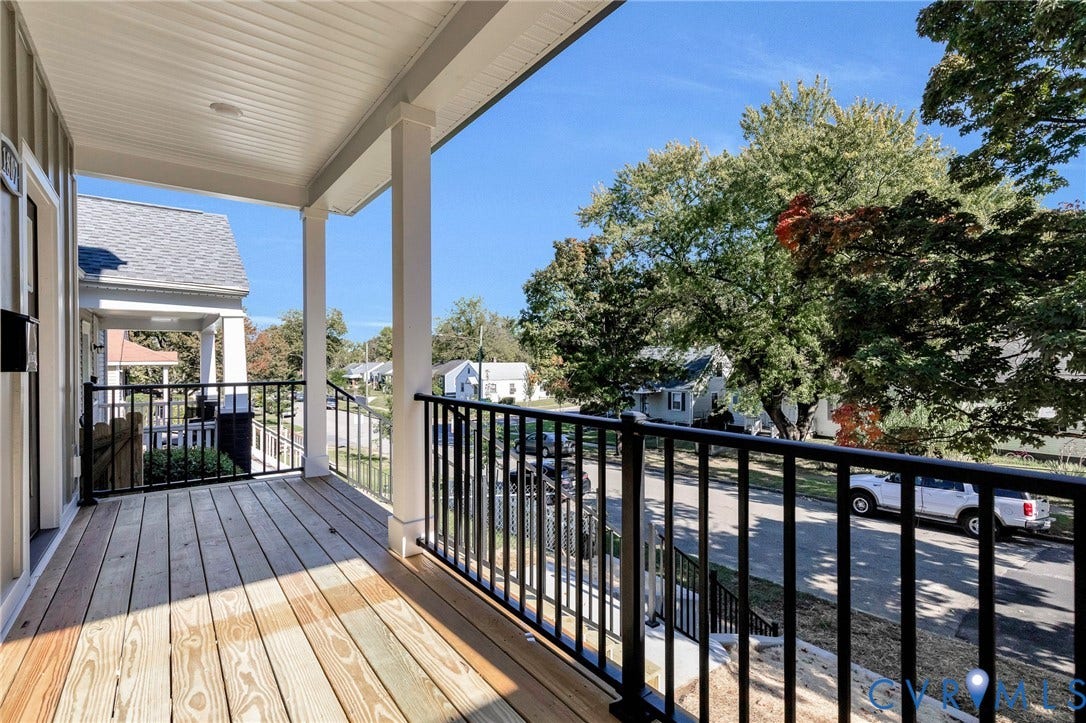 1807 Gordon Avenue, Oak Grove, Oak Grove, VA 23224 Front porch featuring natural wood flooring, white support columns, black metal railings, and a matching black mailbox