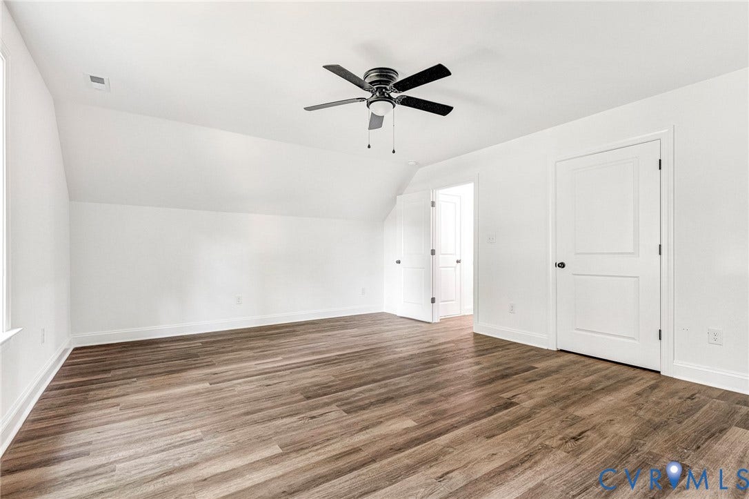 1807 Gordon Avenue, Oak Grove, Oak Grove, VA 23224 Expansive room featuring wood-finish flooring, a contemporary ceiling fan, and crisp white walls