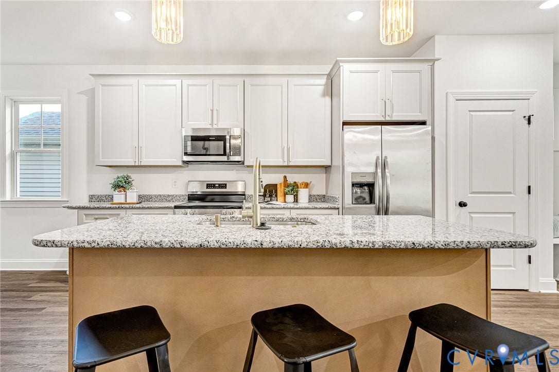 1807 Gordon Avenue, Oak Grove, Oak Grove, VA 23224 Kitchen featuring white shaker cabinetry, stainless steel appliances, speckled stone countertops, and a central island with a sink