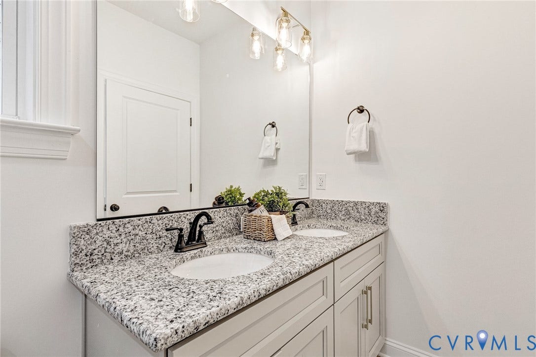 1807 Gordon Avenue, Oak Grove, Oak Grove, VA 23224 Dual undermount sinks with granite countertop, light-toned cabinetry, and brushed bronze fixtures