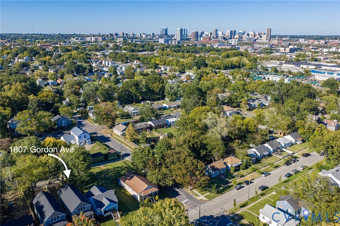 1807 Gordon Avenue, Oak Grove, Oak Grove, VA 23224 Aerial perspective showcasing the residential street with a prominent city skyline in the distance