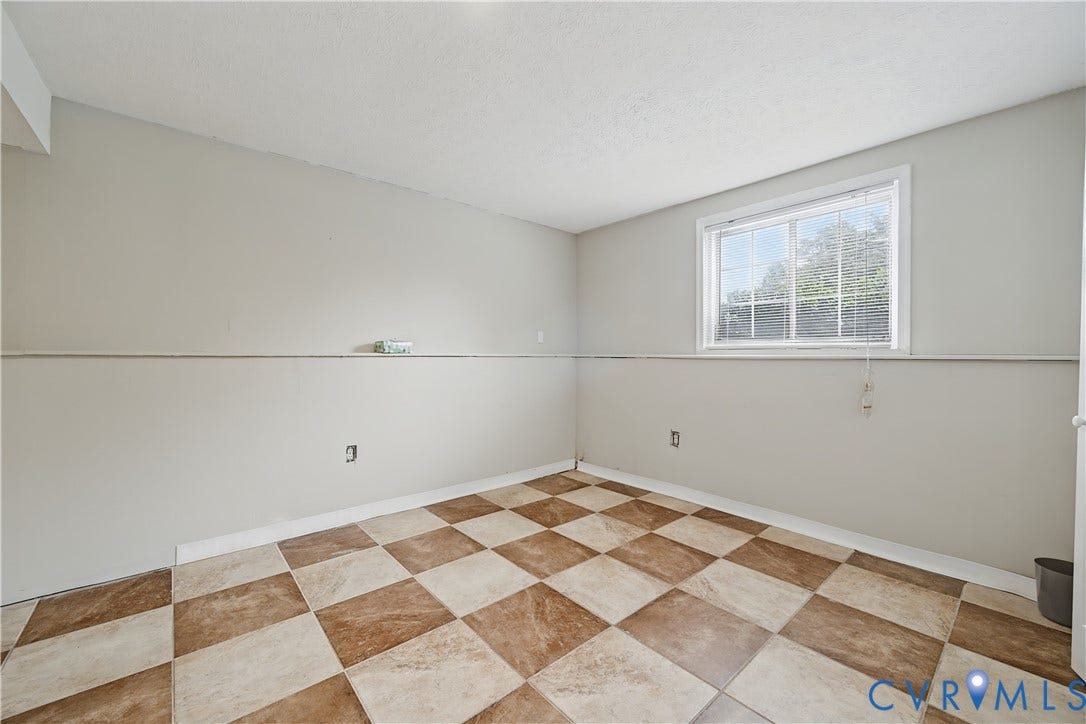 Checkerboard floor pattern, neutral wall tones, and a window with natural light
