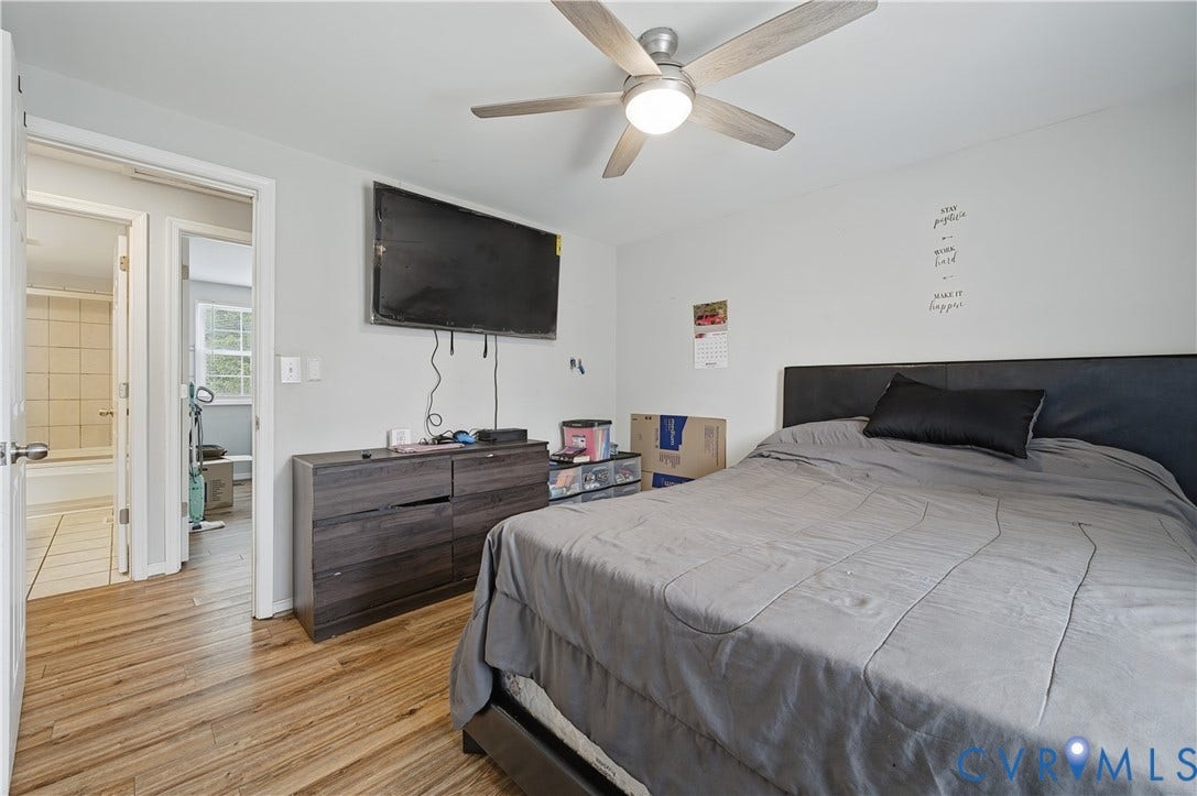 Wood-finish flooring, ceiling fan with integrated lighting, and a neutral wall color