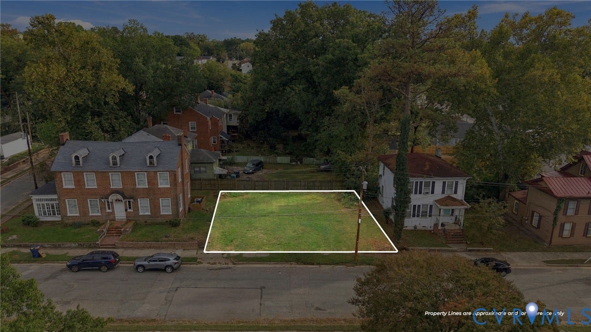 Grassed lot with mature perimeter trees, offering a clear building site