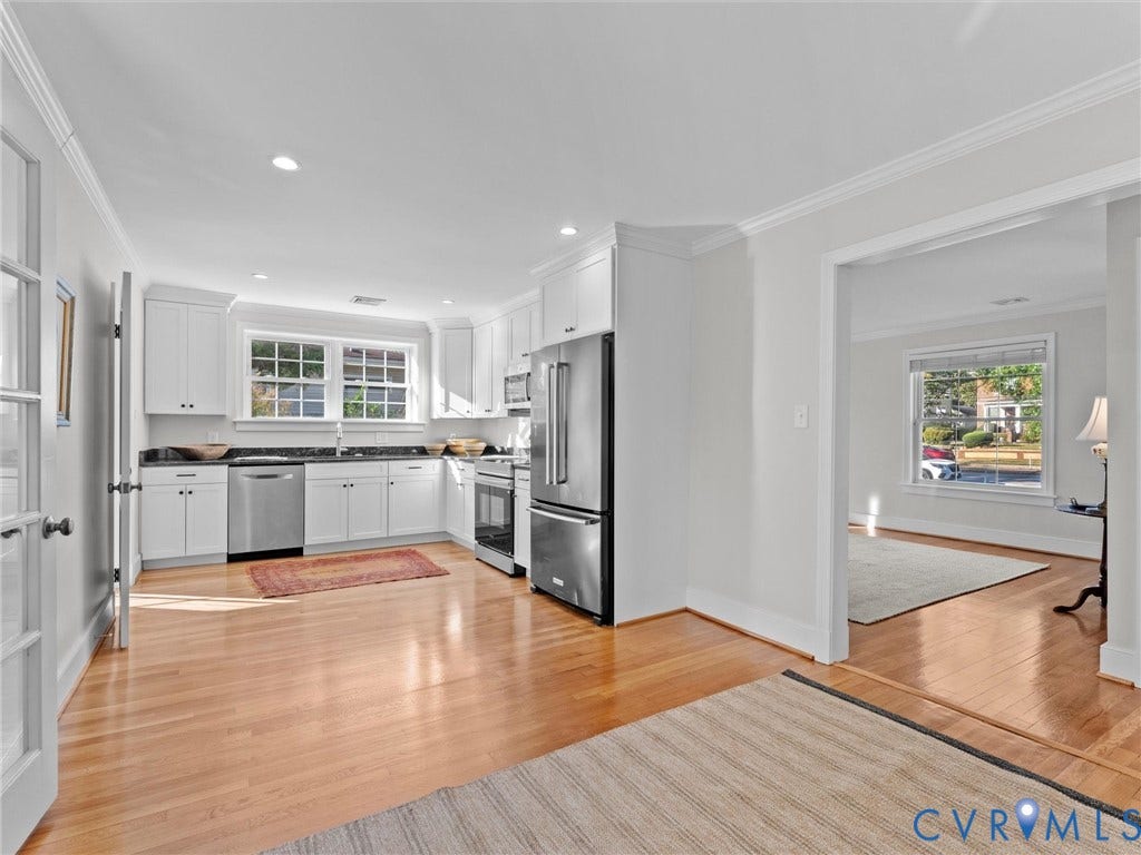 Kitchen featuring wood-finish flooring, white cabinetry, dark countertops, and stainless steel appliances