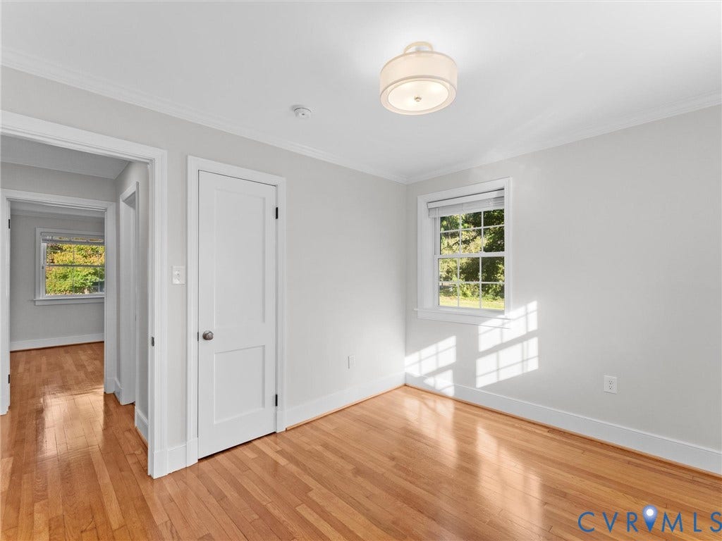 Hardwood flooring, white trim, white walls, and a drum-style ceiling light