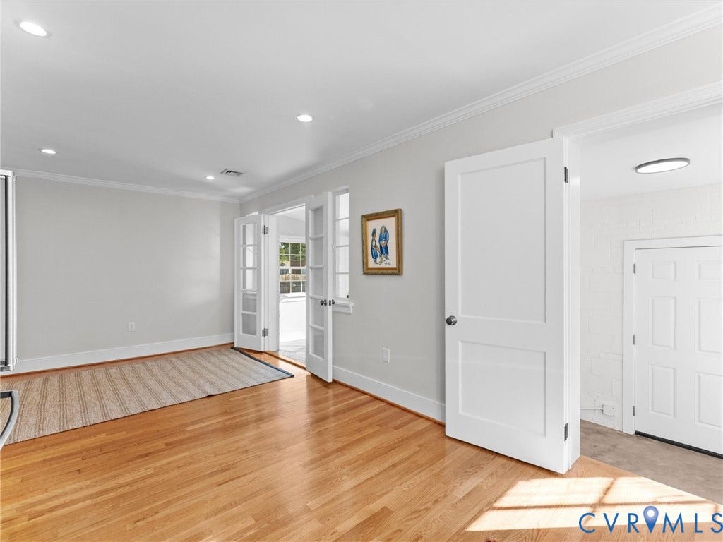 Hardwood flooring, white painted walls, recessed lighting, white crown molding, and white French doors