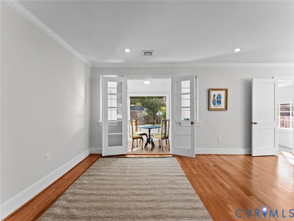 Wood-finish flooring, recessed lighting, and crown molding