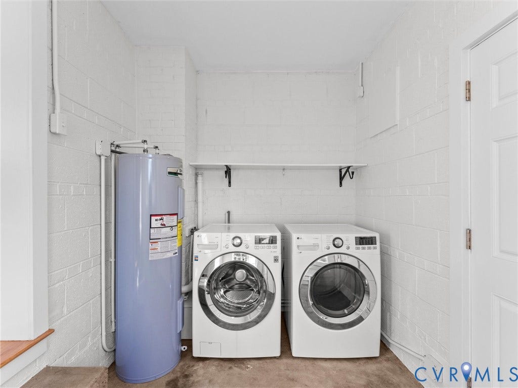 Laundry area featuring a large capacity washer and dryer, a water heater, and a wall-mounted shelf