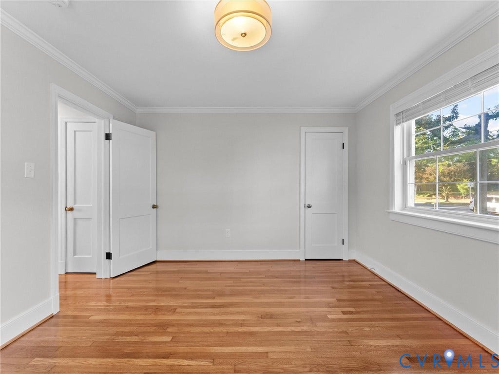 Hardwood flooring, crown molding, white trim, flush mount ceiling light, and window with exterior scenery