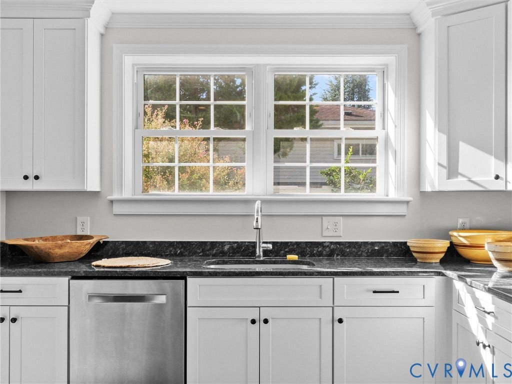 White shaker-style cabinetry, dark speckled countertops, stainless steel dishwasher, and a stainless steel sink with a gooseneck faucet